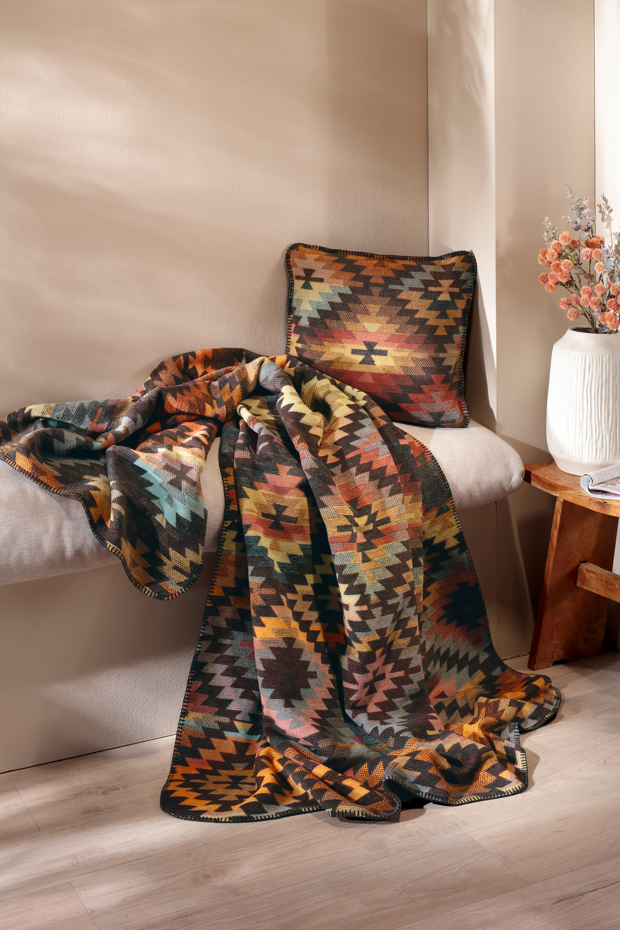 Wohndecke Nomad Glow auf Sitzbank mit passendem Kissen