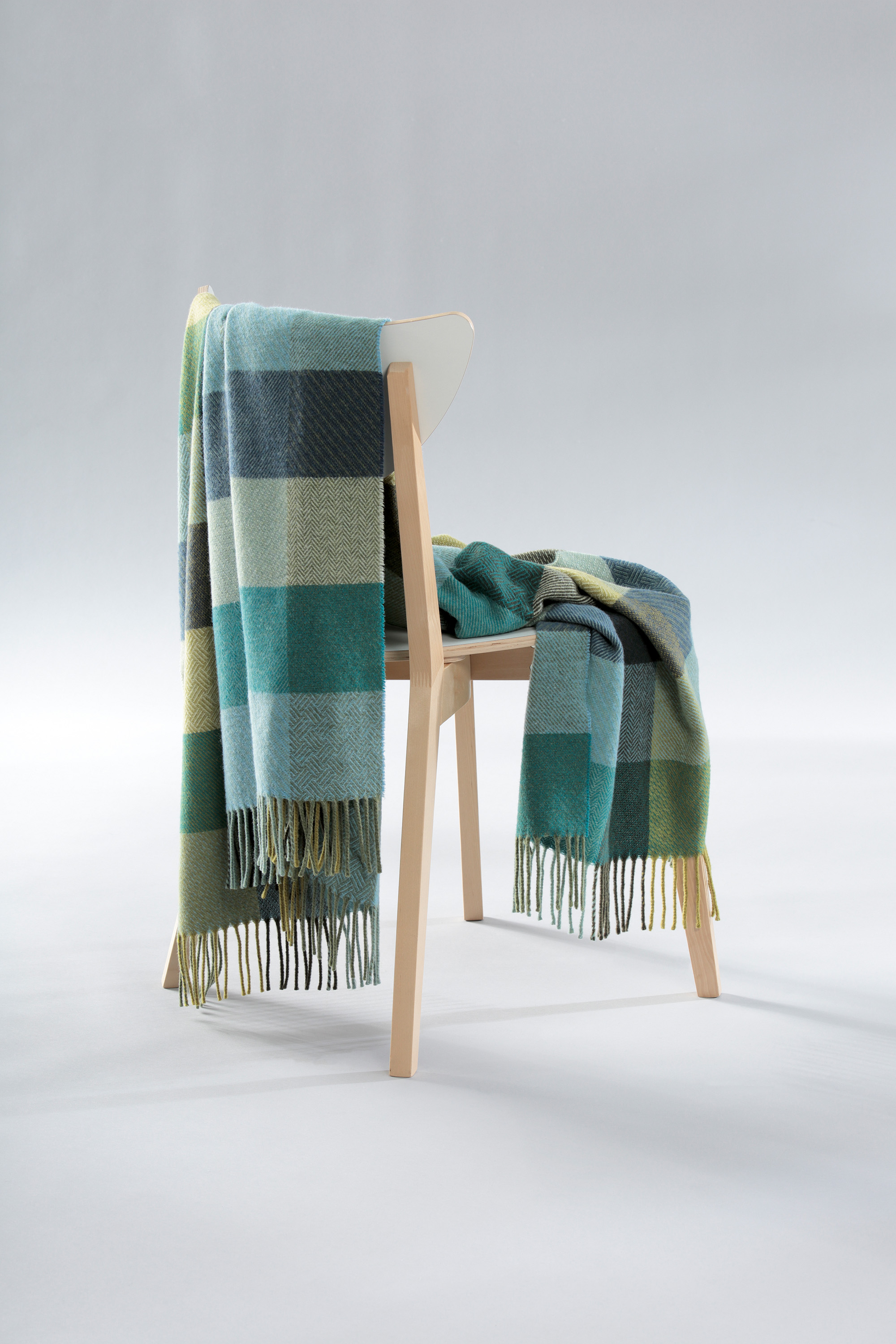 Fransenplaid Green Shades auf Stuhl gelegt