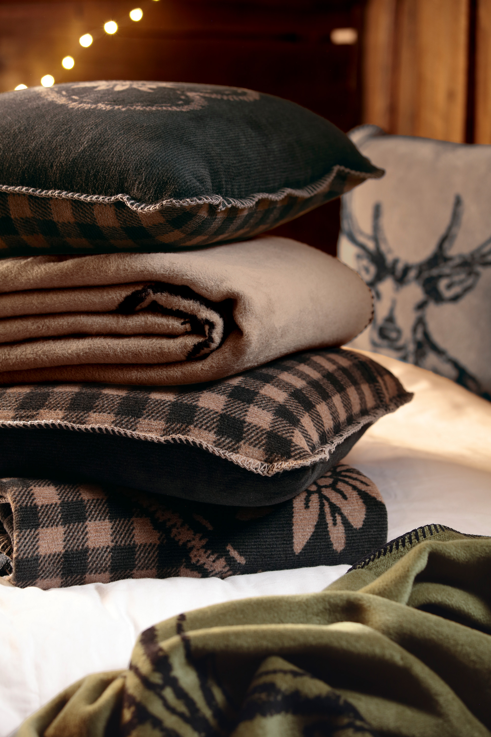 Wohndecken Deer und Alp Charm mit passenden Kissen gestapelt