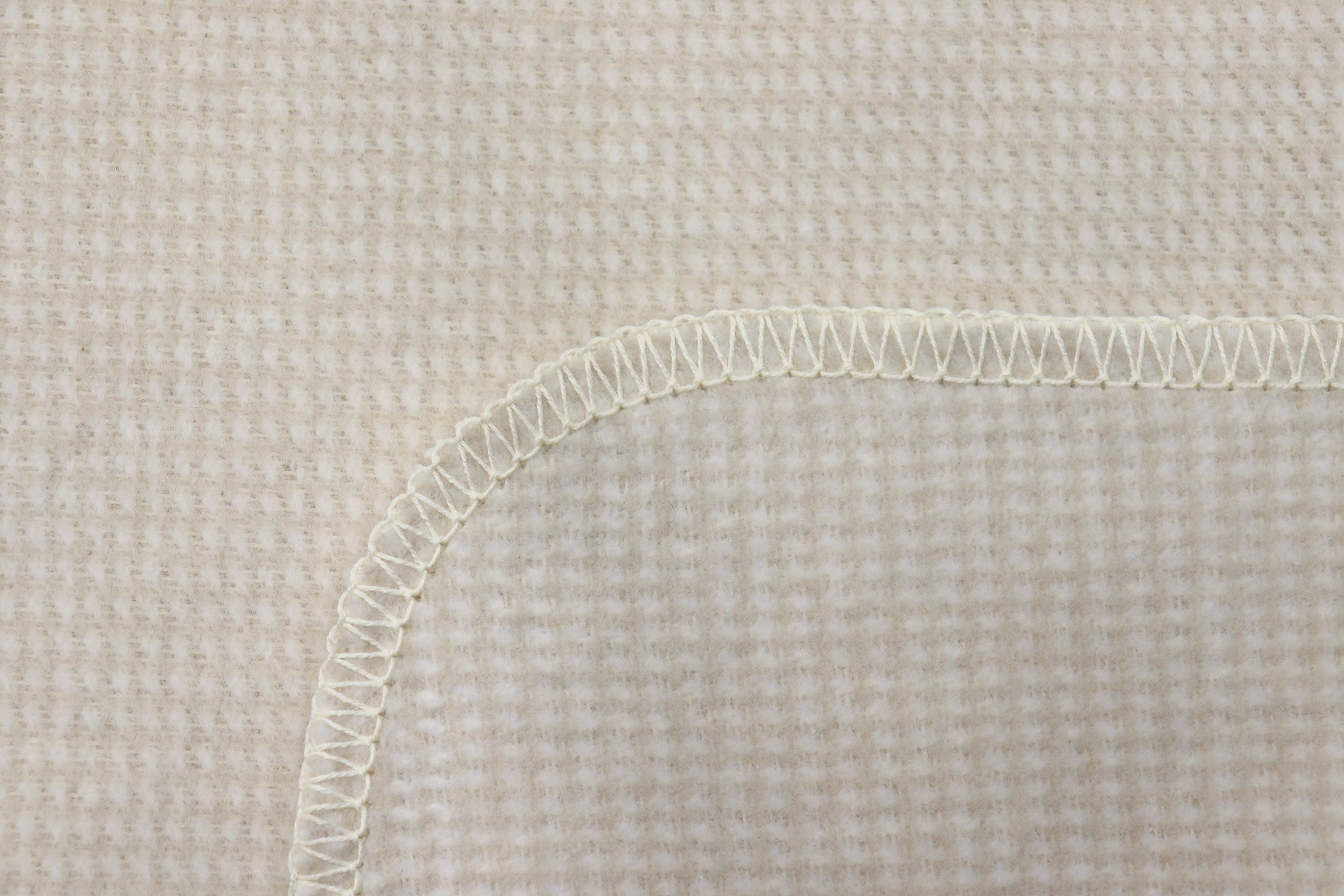 Baumwolldecke "Cotton Comfort" mit feinem Muster in beige in 150x200 cm - Detailaufnahme Overlock-Stich