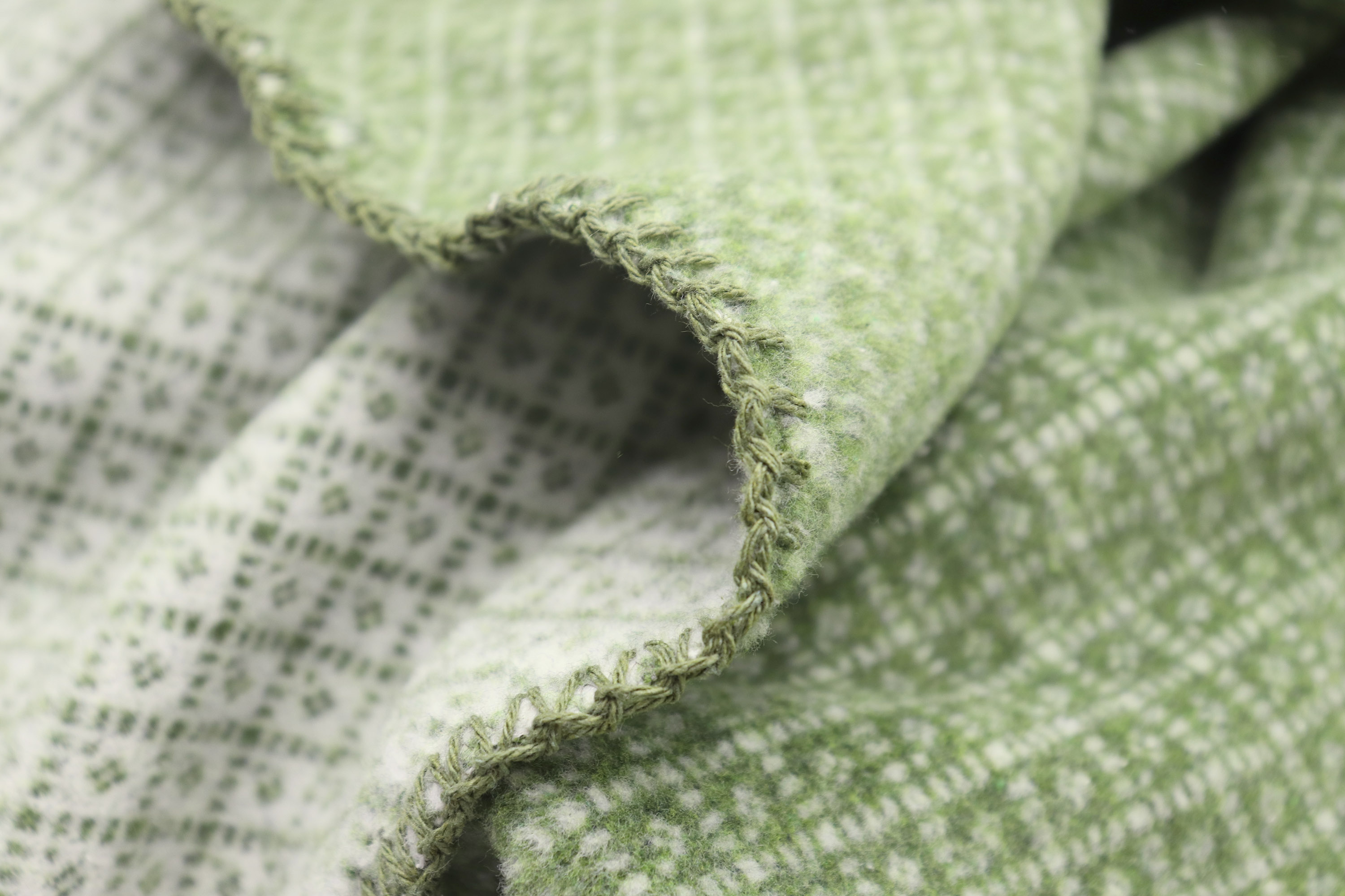 Nachhaltige Kuscheldecke "Tiny green" aus Recycling-Garn mit minimalem Muster in grün - Detailaufnahme Flor