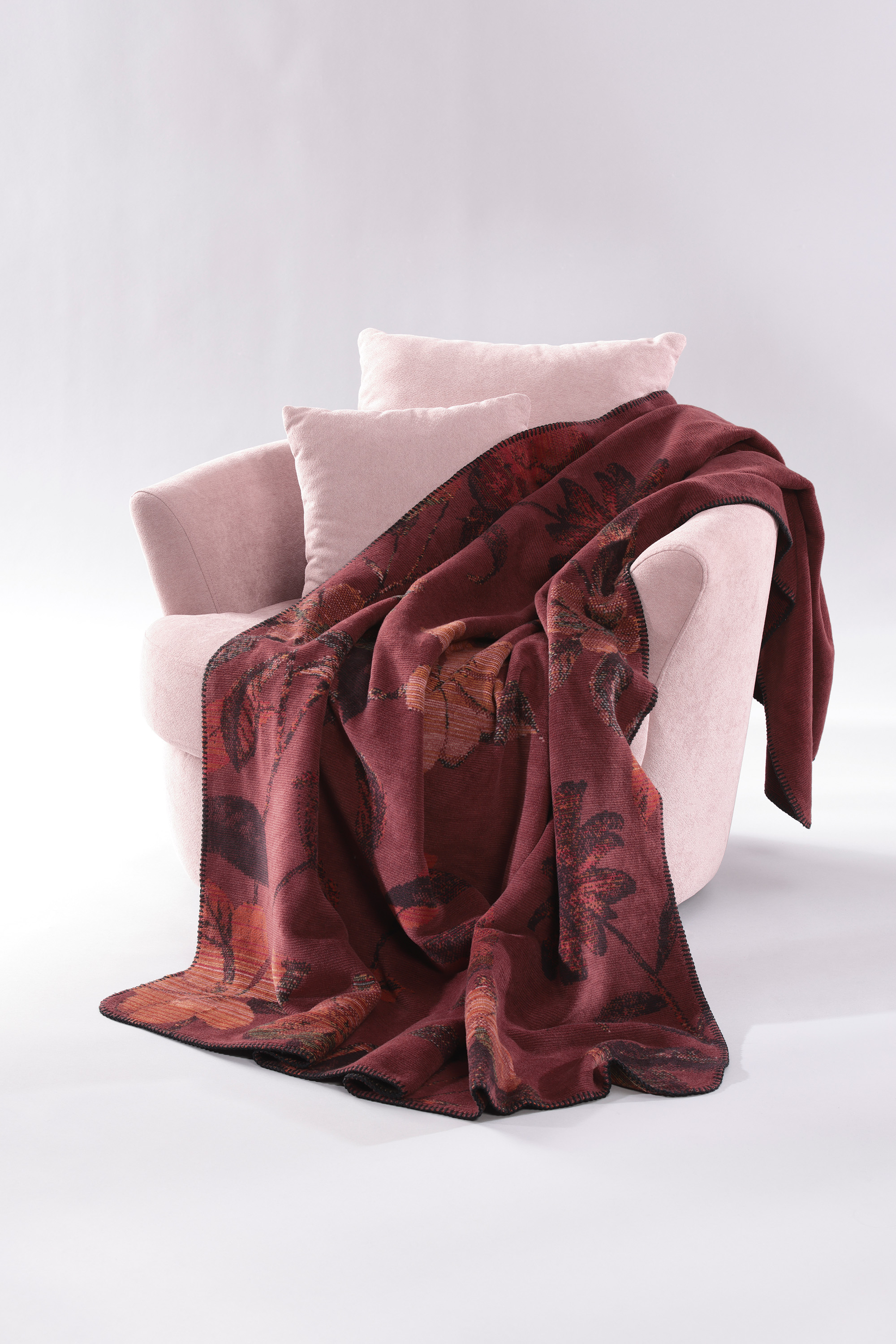 Wohndecke Velvet Bloom auf Sessel gelegt