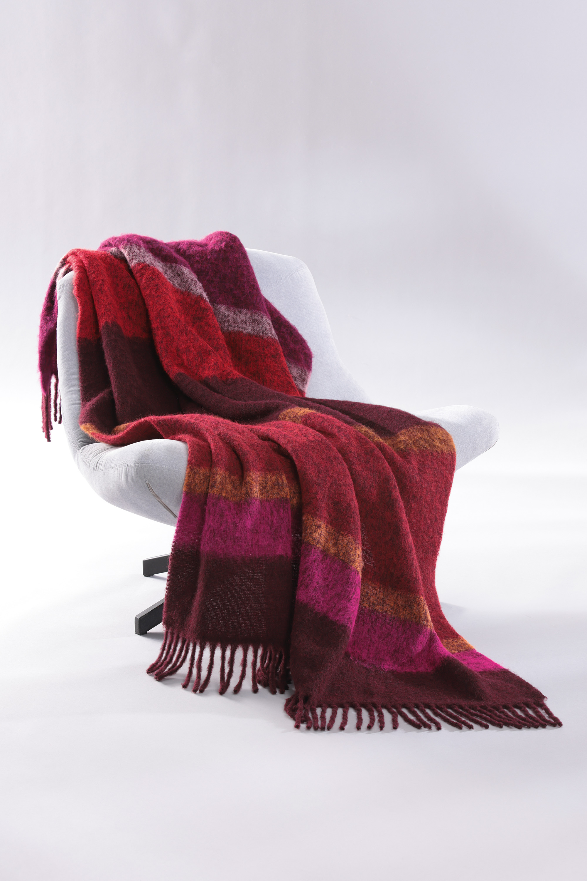 Fransenplaid Mohair Look Crimson auf Sessel gelegt